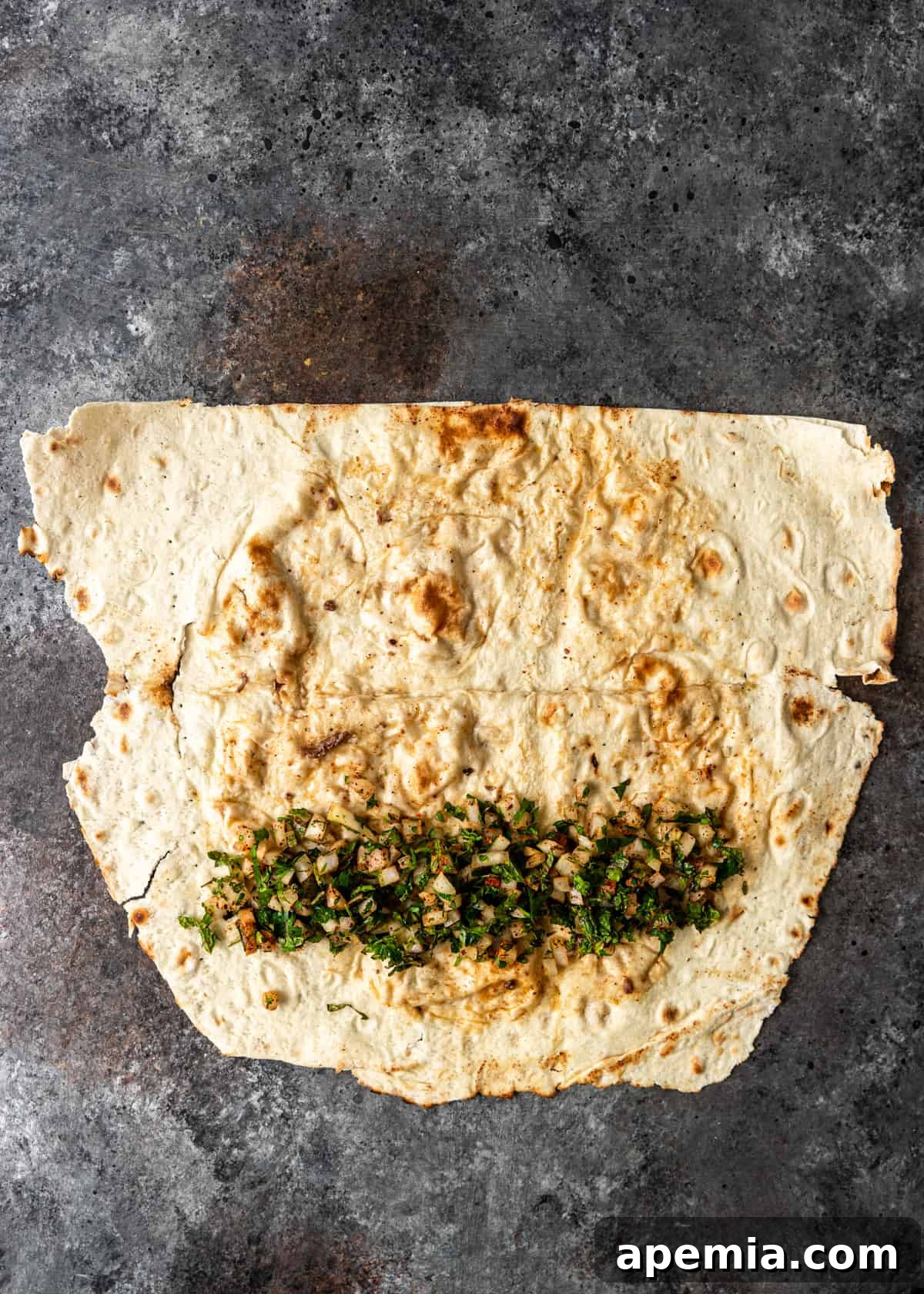 overhead process shot: onion and herb mixture on a steamed wrap before folding