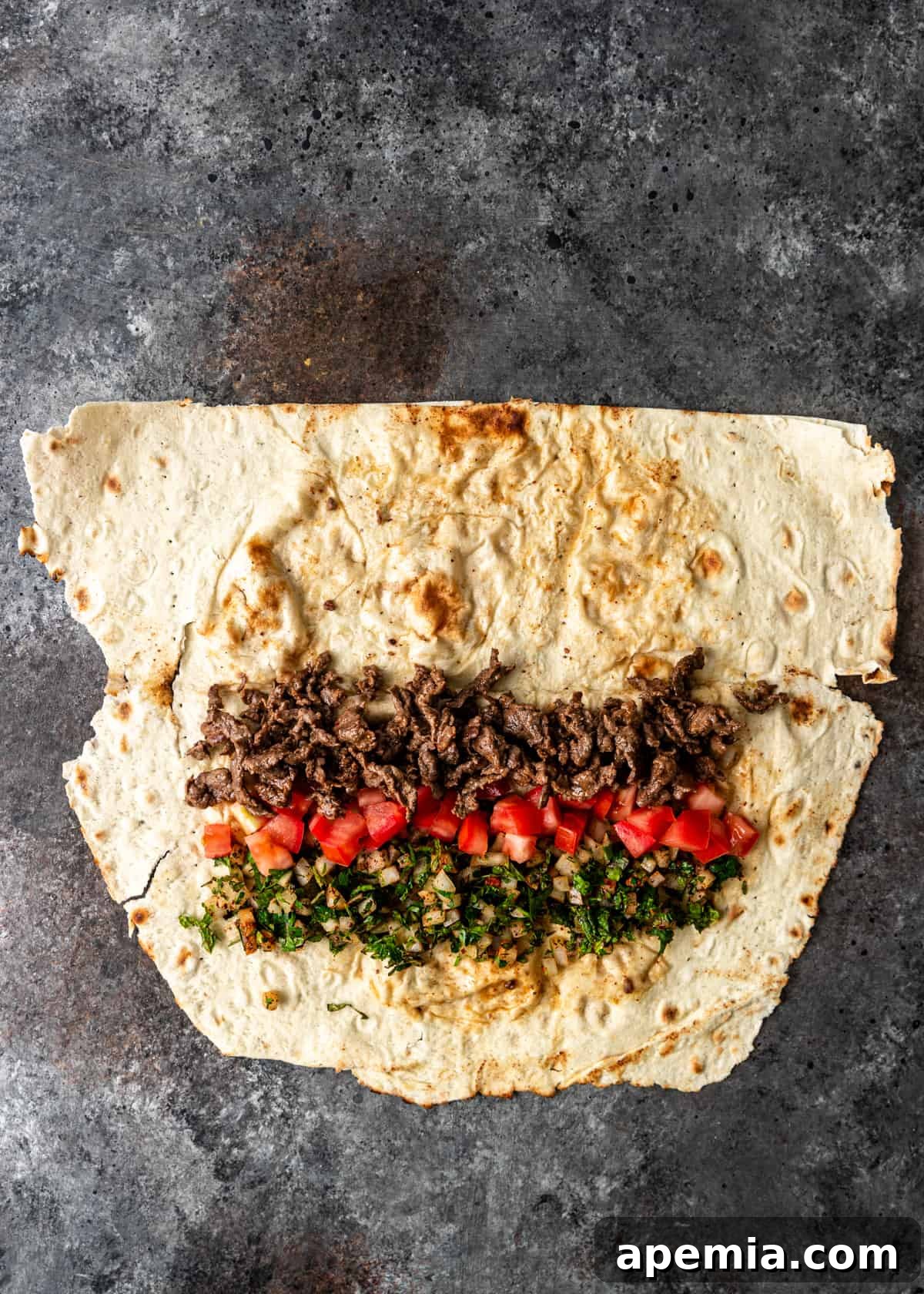 overhead process shot: seasoned beef and other ingredients on wrap before folding