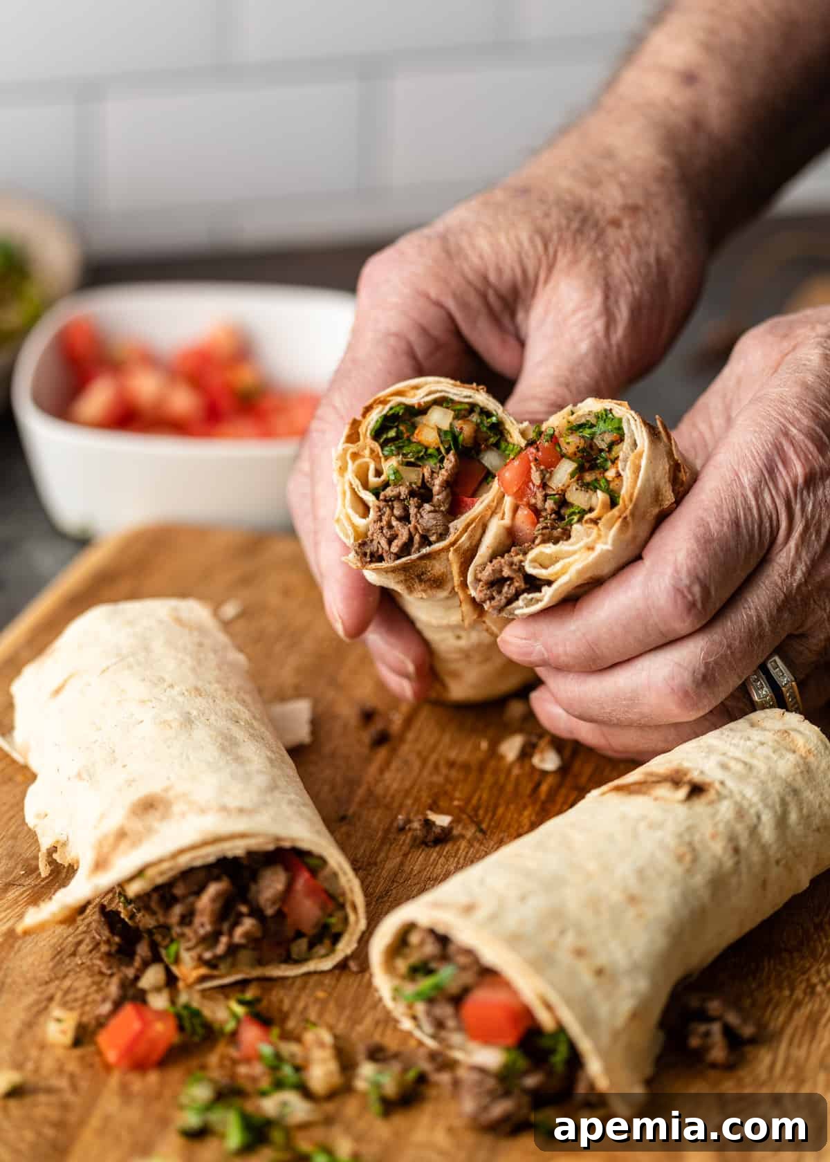 closeup: hands holding a cut tantuni sandwich