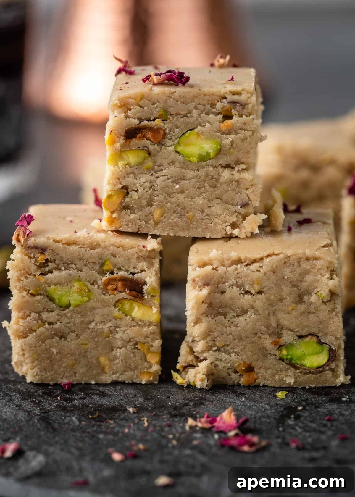 Side view close-up of three pieces of Middle Eastern sweet stacked invitingly.