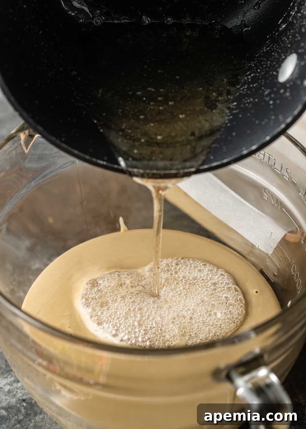 Overhead process shot: Pouring sugar syrup into tahini mixture for Middle Eastern sweet