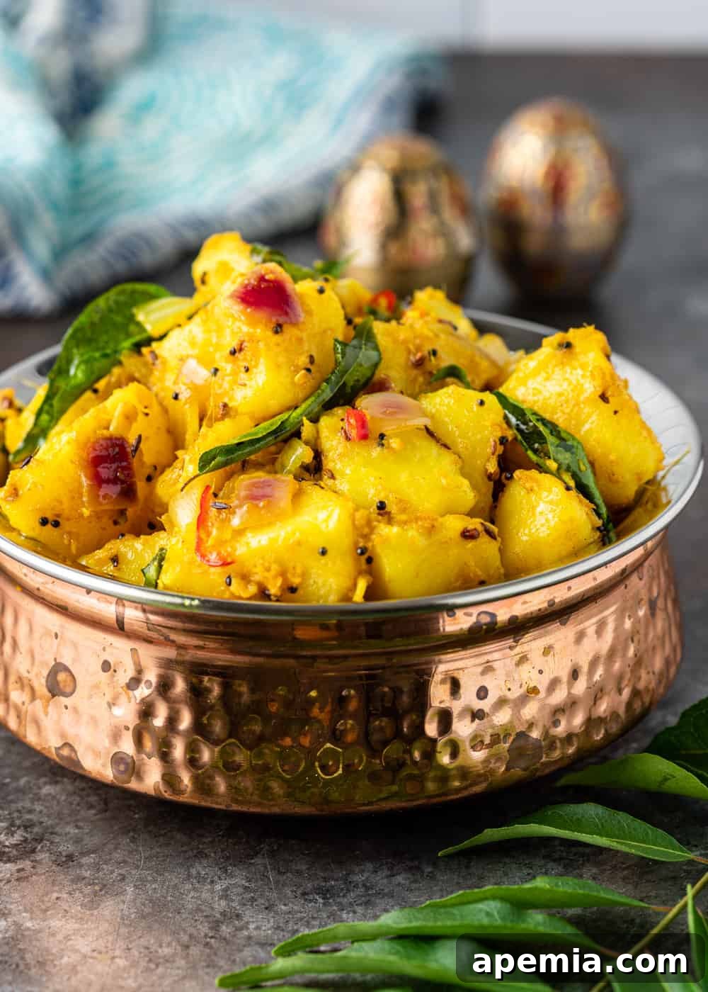 Close-up side view of a comforting bowl of Aloo Masala, highlighting the rich texture and vibrant colors of the Indian potato dish, ready to be enjoyed.