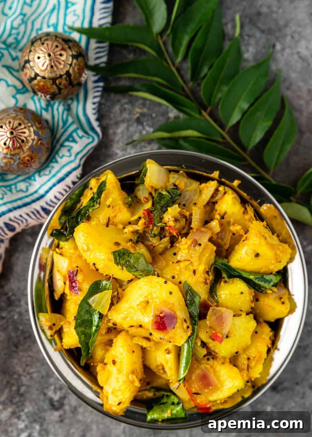 Overhead view of Aloo Masala, garnished with fresh cilantro, showcasing a warm potato dish with earthy Indian spices and rich flavors.