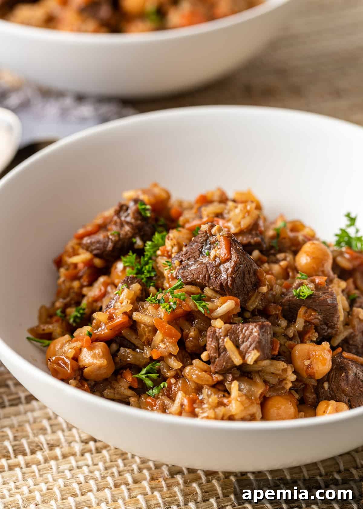 side view: white bowl full of beef plov