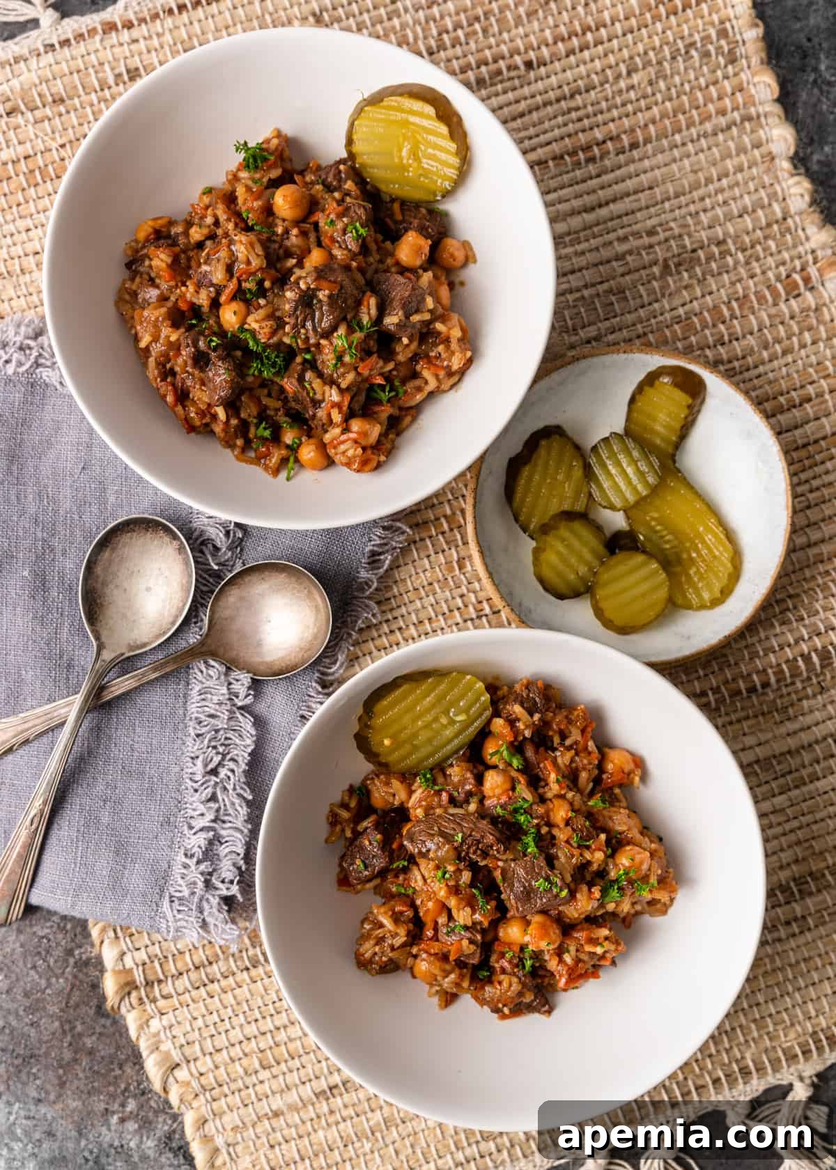overhead: beef rice pilaf in bowls and a plate with pickles