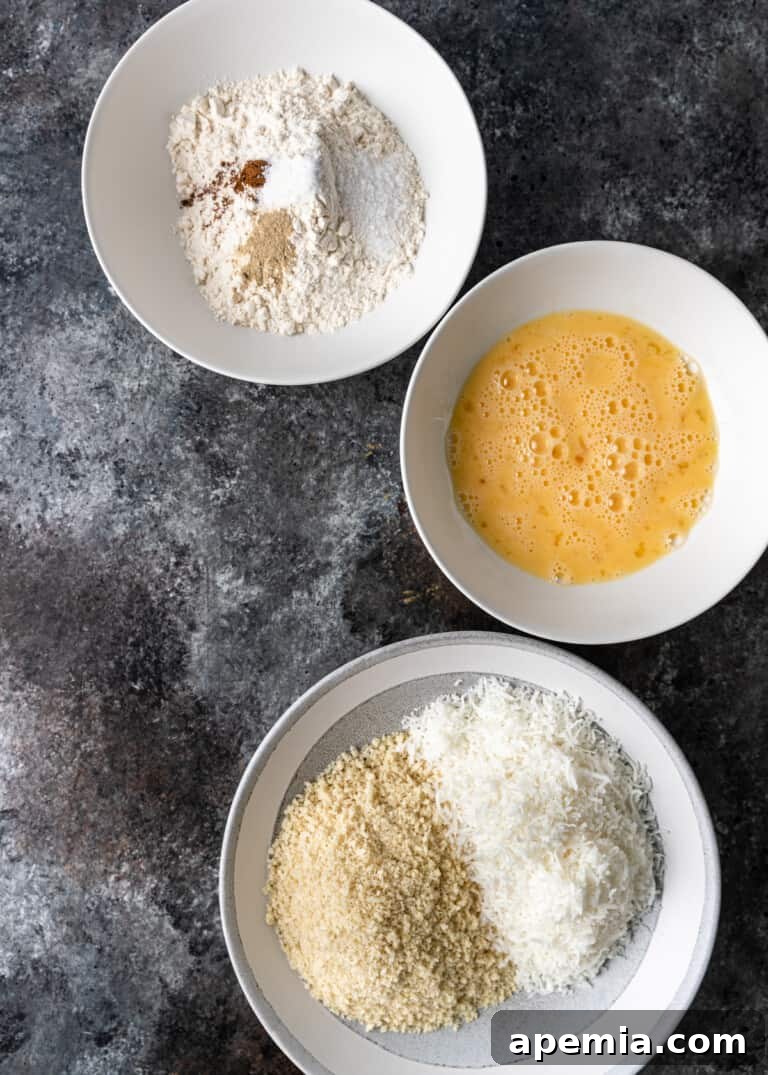Sweet Coconut Crunch Shrimp 4 Overhead process shot: three bowls set up for the dredging station, containing flour mix, beaten eggs, and coconut-panko mix.