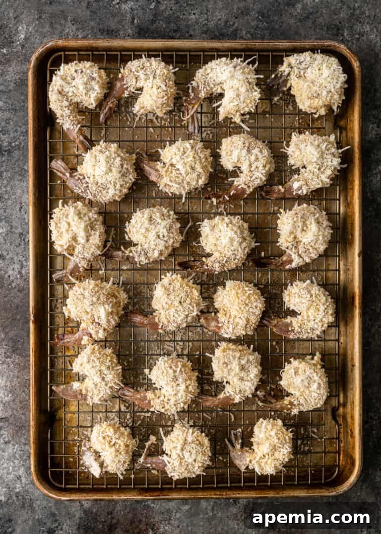 Sweet Coconut Crunch Shrimp 5 Overhead process shot: several breaded shrimp resting on a wire rack, perfectly coated and ready for frying.