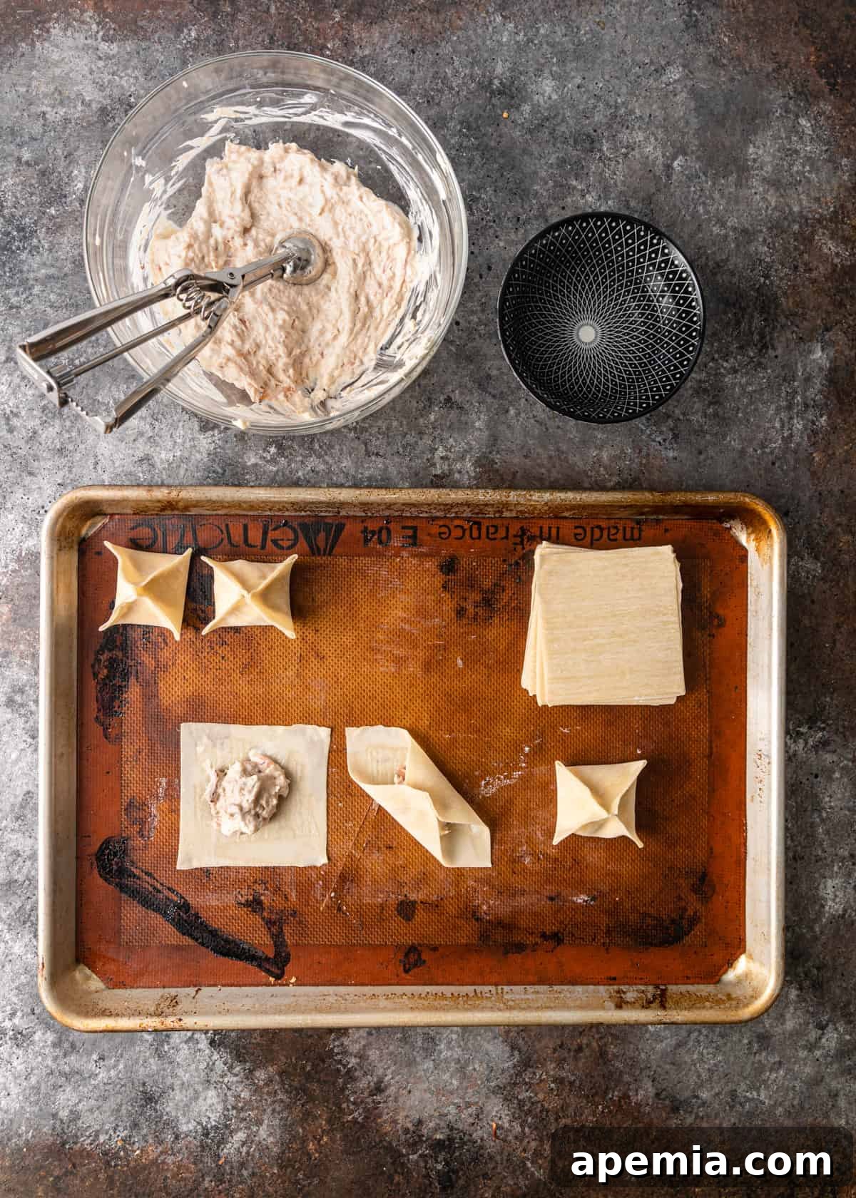 overhead process shot: showing how to make crab rangoon and sitting on a baking sheet