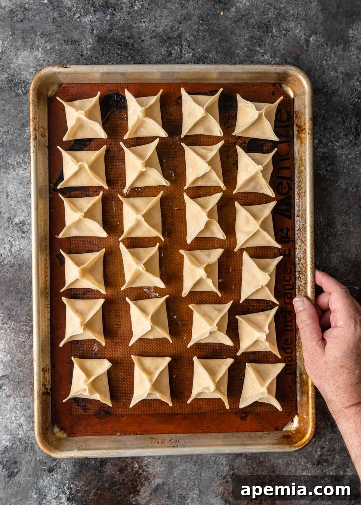 overhead: ready to cook Crab Rangoon sitting on baking sheet