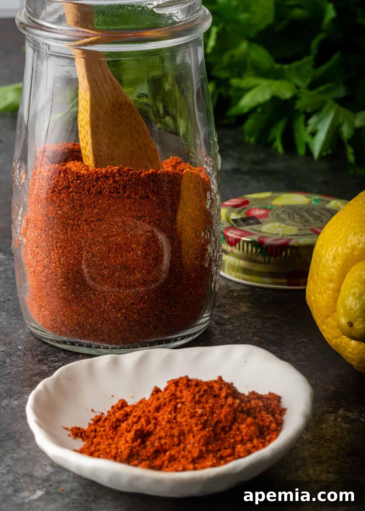 Another perspective of Lemon Harissa Powder in a glass jar, highlighting its fine texture and rich color.