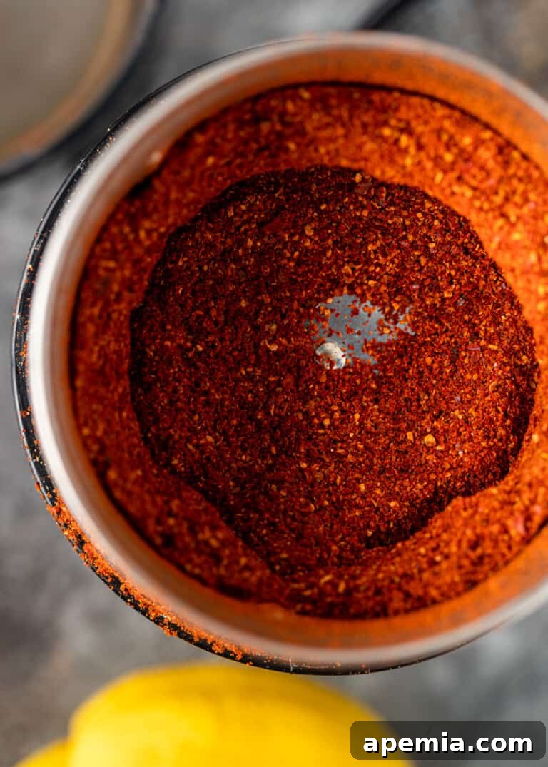 Finely ground Lemon Harissa Powder in a spice grinder or food processor, showcasing its vibrant texture.