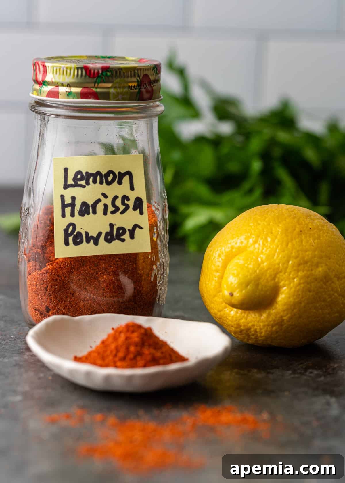 A jar of ready-to-use Lemon Harissa Powder with a spoon, highlighting its ease of access.