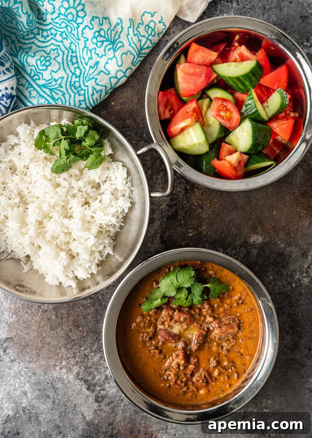 Ultimate Creamy Dal Makhani 4 serving bowls of black dal, rice and cucumbers with tomatoes