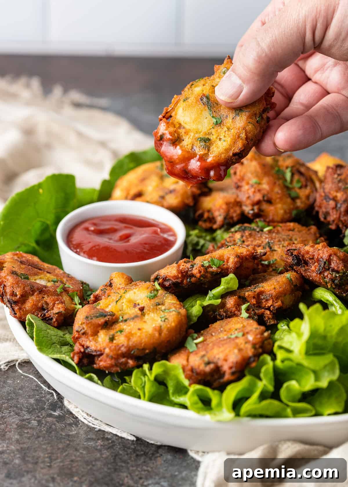dipping Potato Pakora into sauce