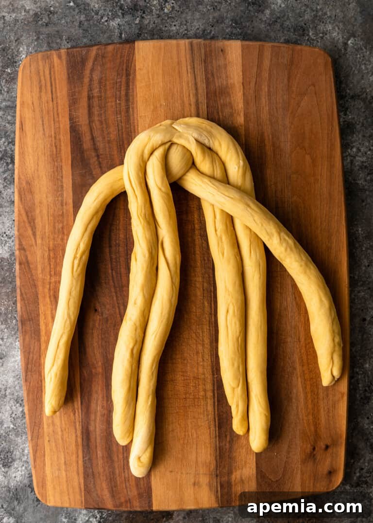 Process shot: Further along in the Challah braiding, showing the developing pattern on a cutting board.