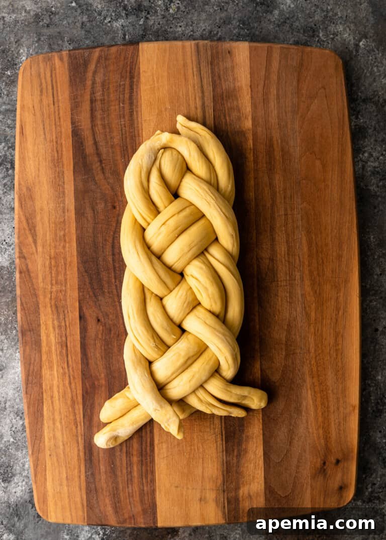 Process shot: The final stages of braiding the Challah, preparing to pinch the ends.