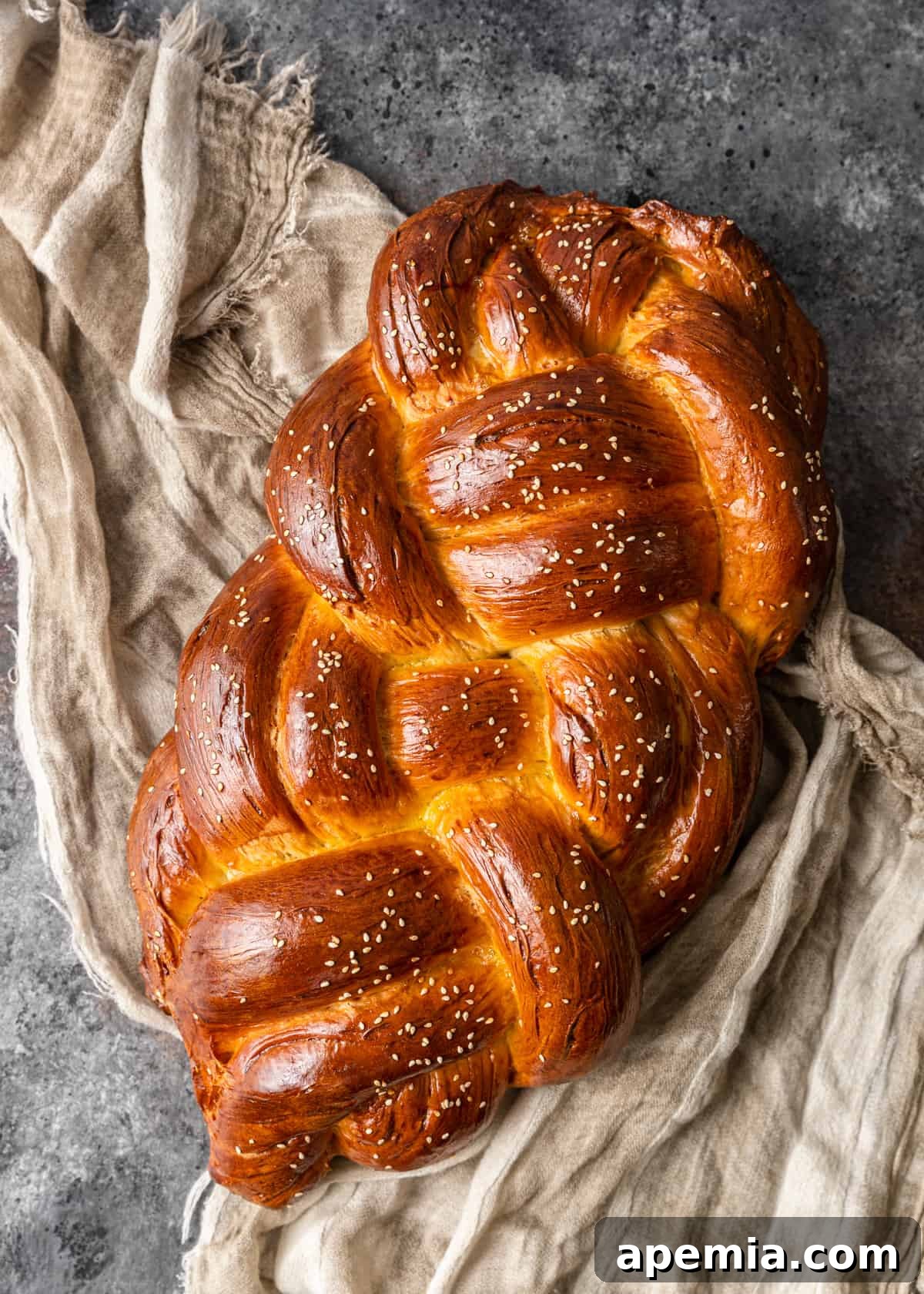 Overhead view of a beautiful, fully baked Challah bread presented on a tea towel, ready to be served.