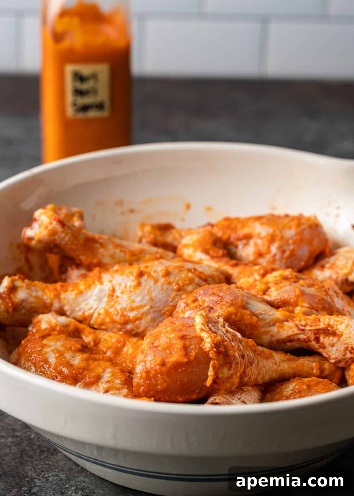 Fiery Peri Peri Chicken 5 Closeup side view of raw chicken drumsticks generously coated in rich Peri Peri sauce