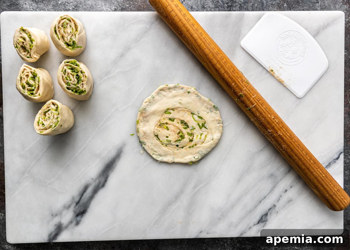 overhead process shot: a rolled out spring onion pancake, ready for pan frying