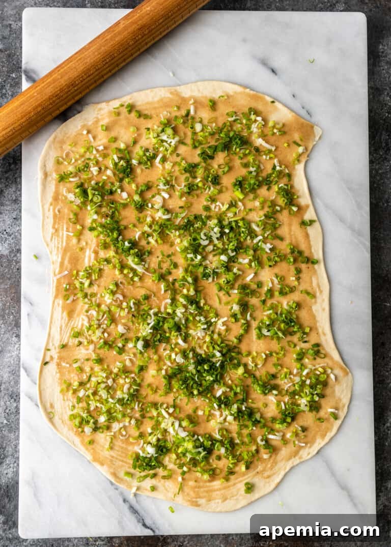 overhead process shot: topping the dough with minced scallions