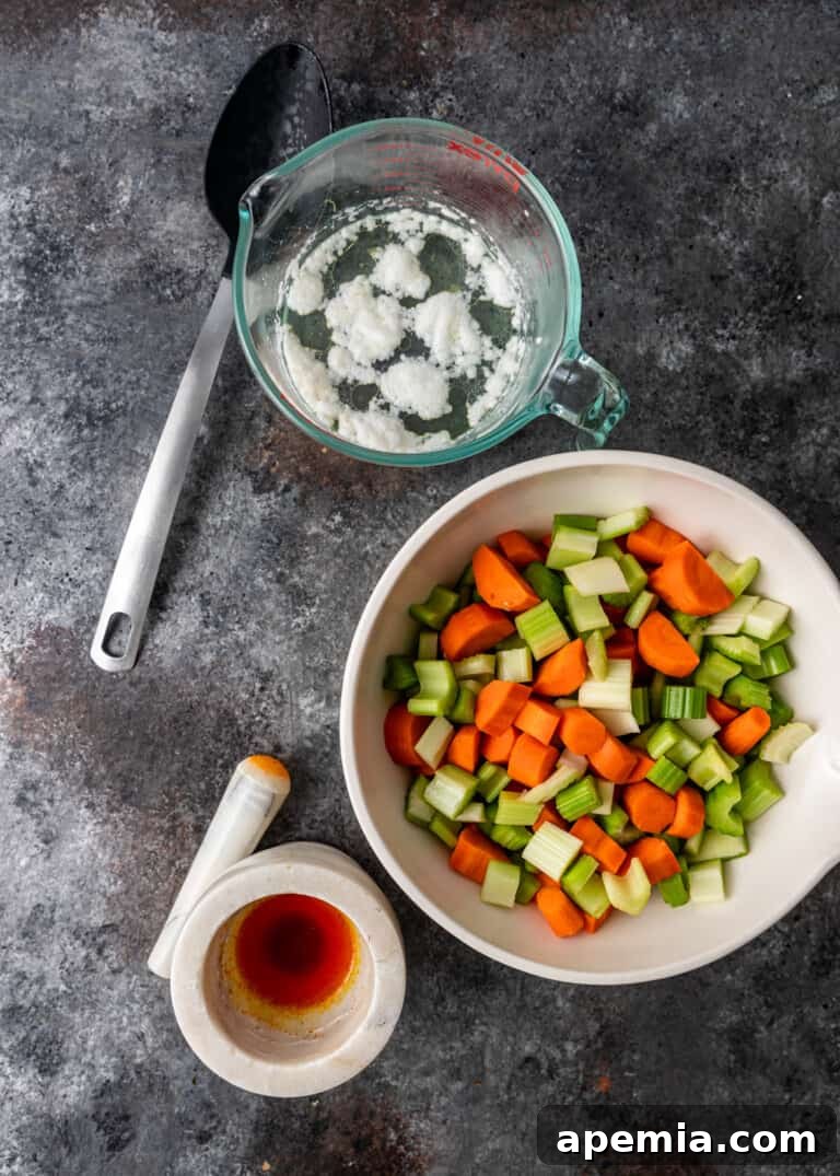 overhead process shot: titled image (and shown) skim foam off simmering chicken & chopped vegetables in a bowl