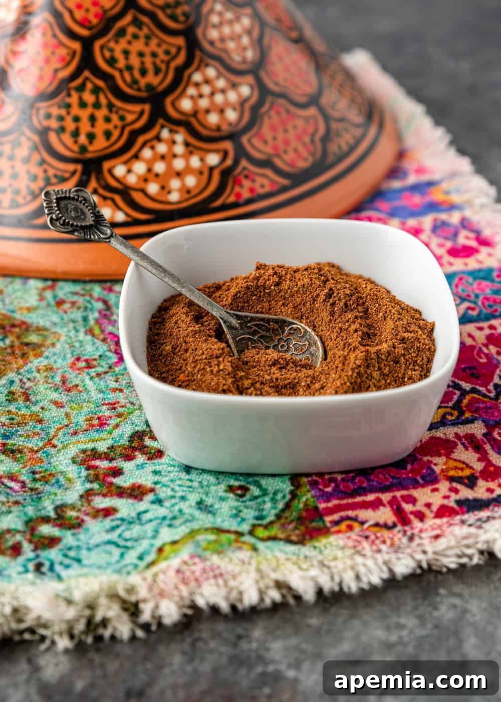 Homemade Middle Eastern spices in a white bowl with a spoon, ready for serving or storage.