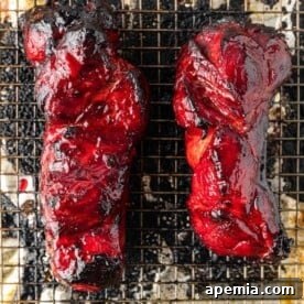 Overhead photo of two large Char Siu roasts, perfectly glazed and ready for slicing, captured with professional lighting.
