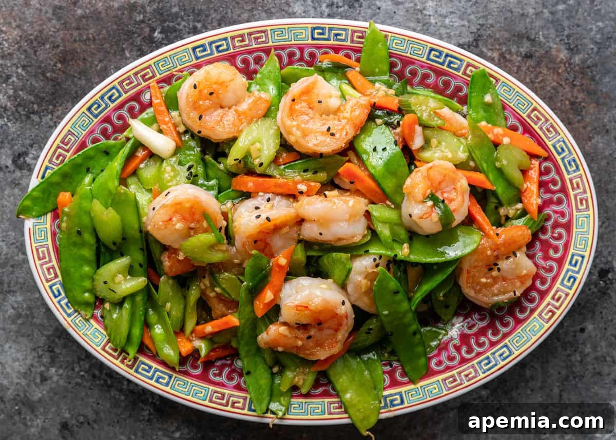 A vibrant platter showcasing perfectly cooked snow peas and succulent shrimp, ready to be enjoyed.