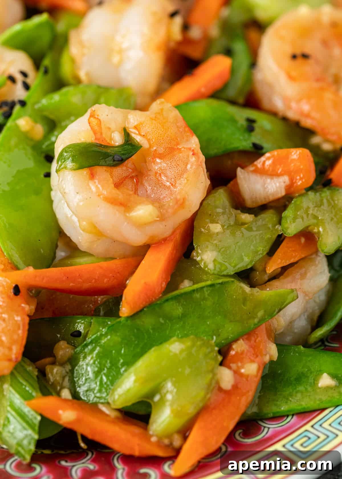 A close-up view of succulent shrimp perfectly cooked and mixed with vibrant snow peas.