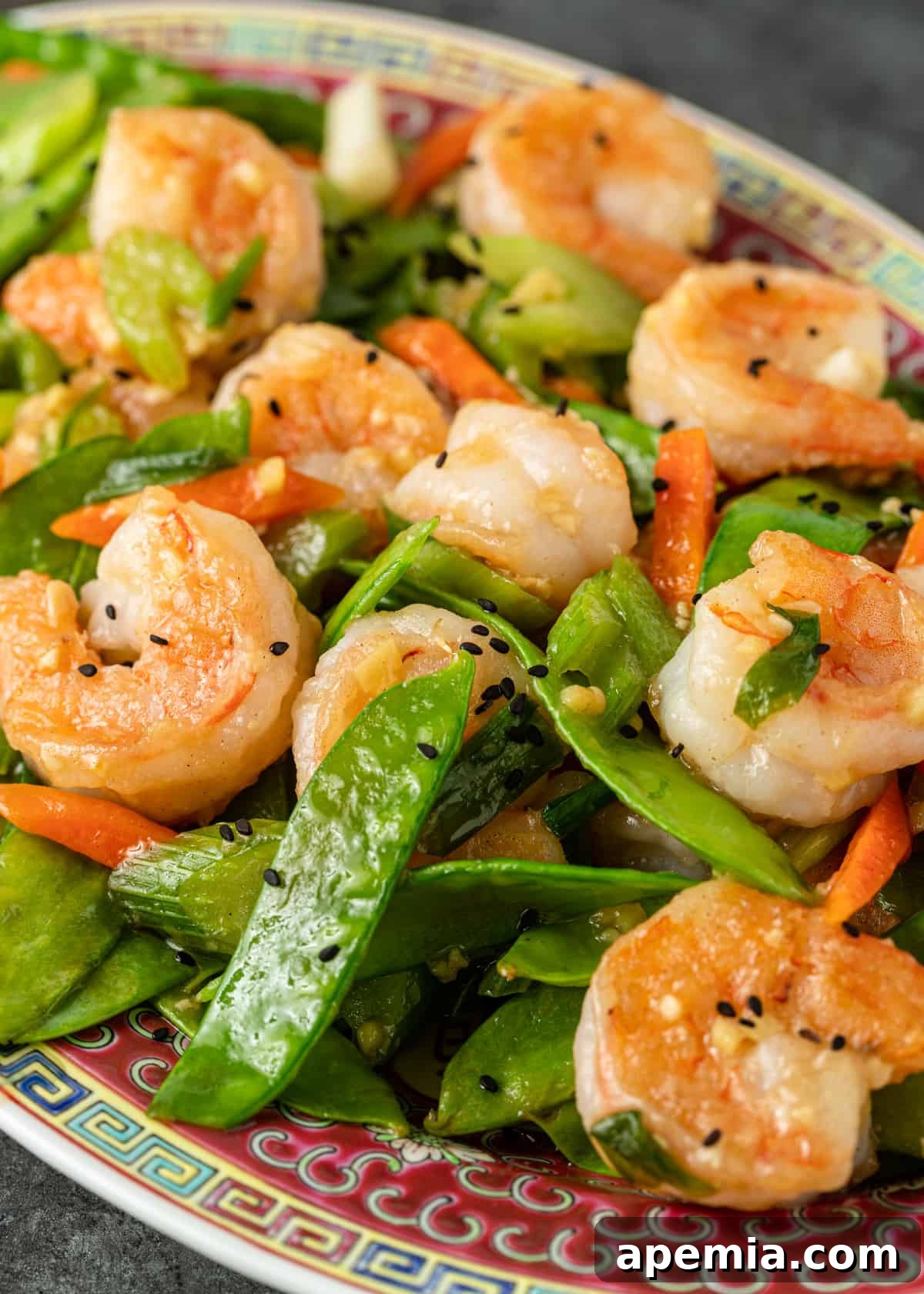 A side view of a large platter showcasing the delightful shrimp and snow peas dish.