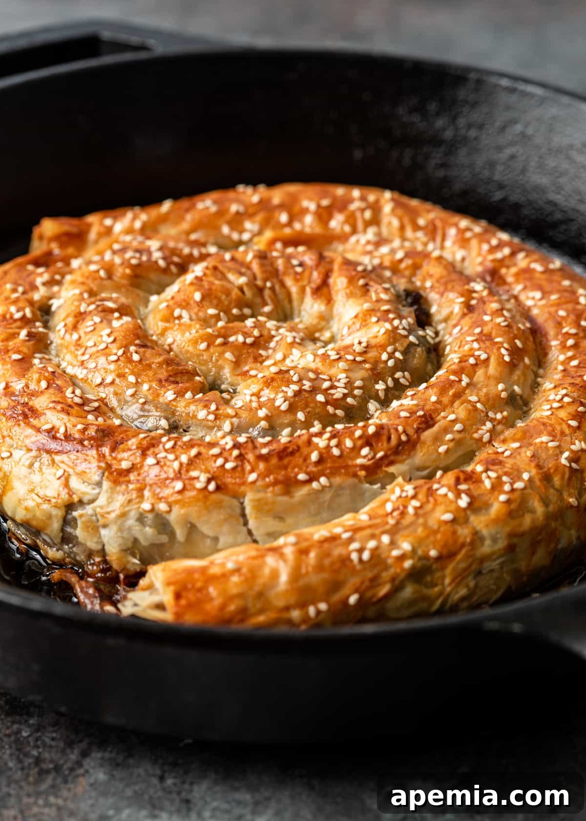 closeup: cooked burek in a skillet with sesame seeds on top 