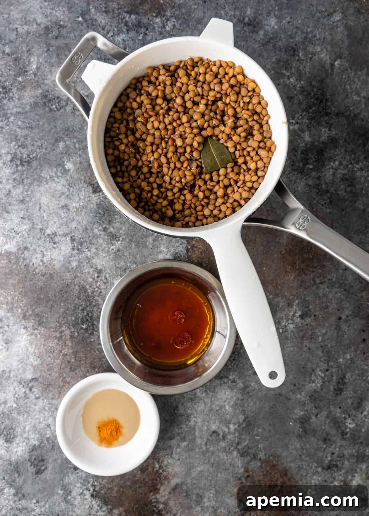 overhead process shot: lentils in white bowl along with other ingredients in white and silver bowl