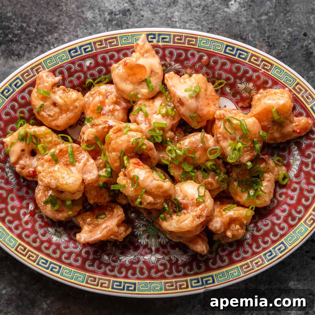 overhead: colorful platter with bang bang shrimp garnished with fresh green onions