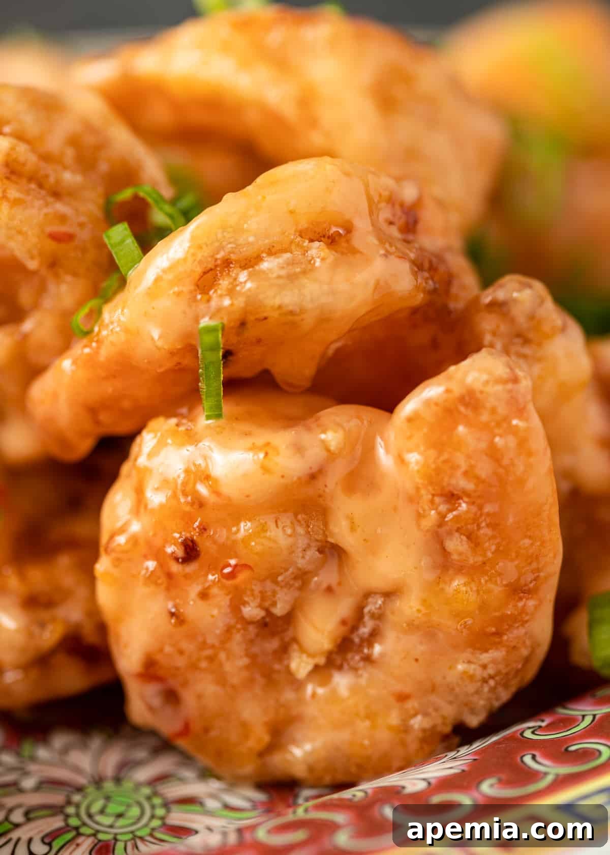 closeup: bang bang shrimp on a platter, ready to serve with a garnish of green onions