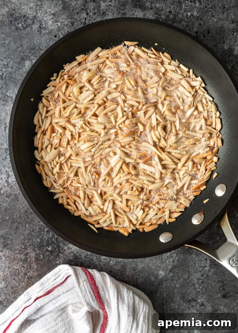 Process shot: Frying blanched almonds in a pan until golden brown for the pastilla filling.