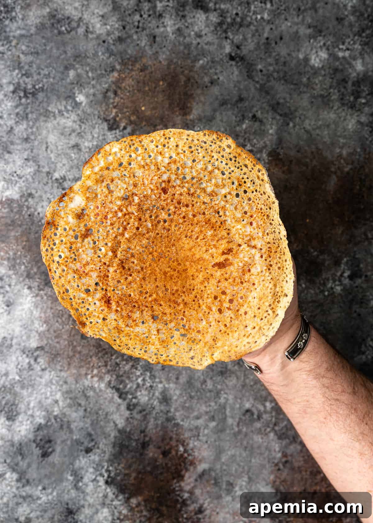 overhead: hand holding an Indian crepe