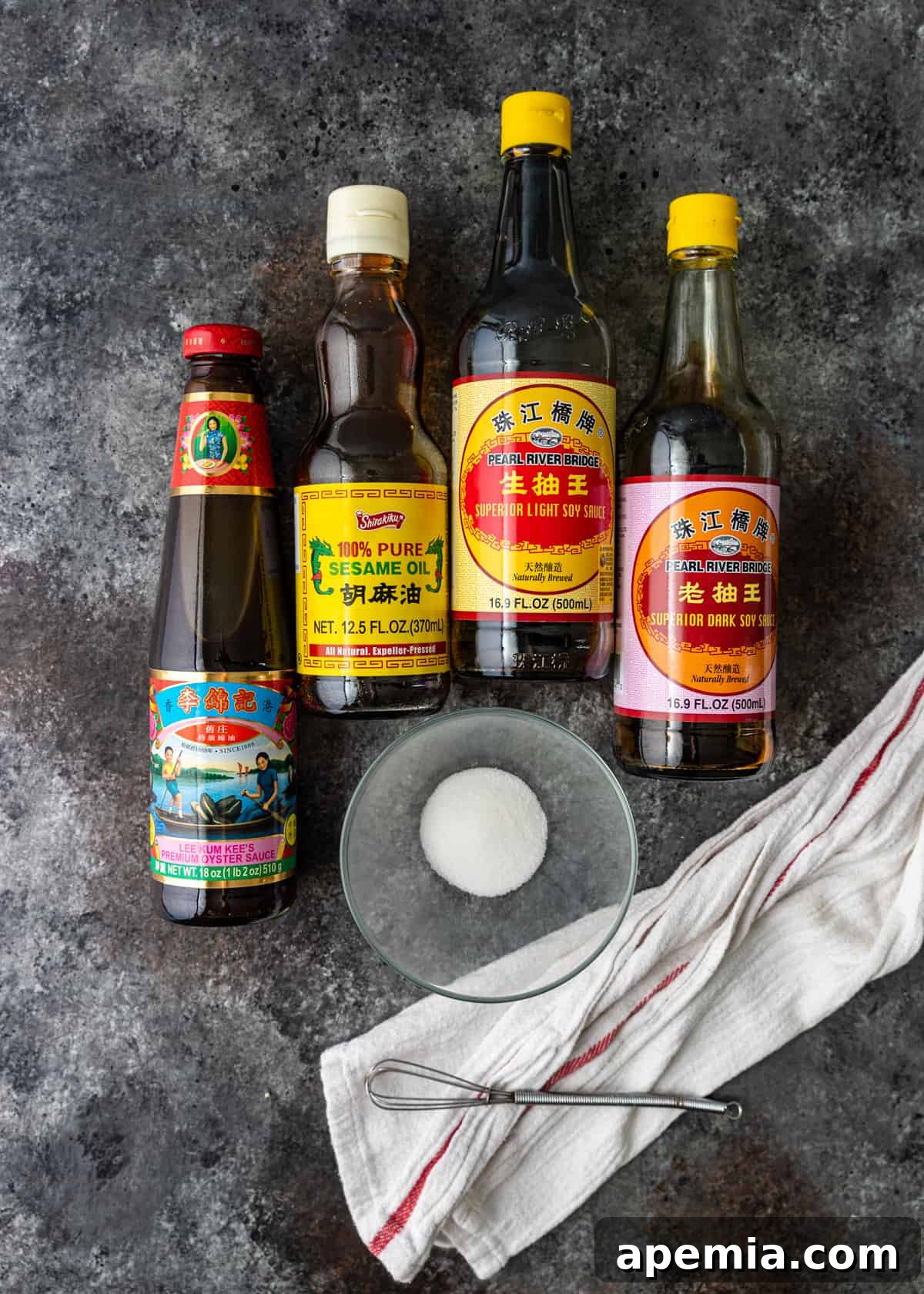 Overhead process shot: Bottled oils and sauces arranged on a counter, ready to be combined to make the delicious lo mein stir-fry sauce.