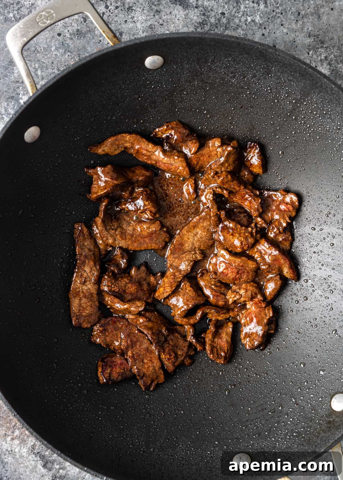 process shot showing beef being stir-fried in a wok