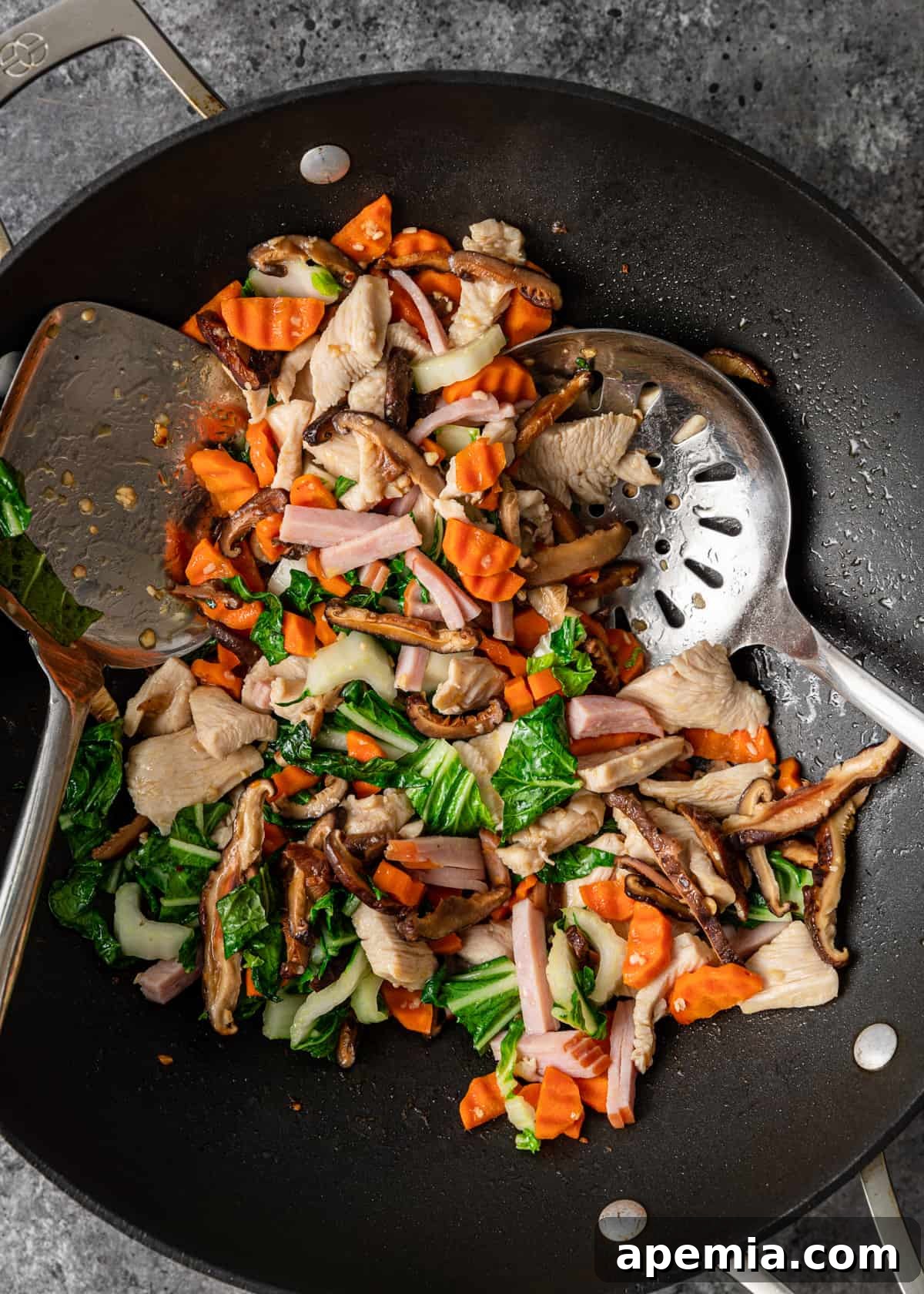 Overhead view of a wok filled with beautifully cooked ingredients for Sizzling Rice Soup, glistening and ready for broth
