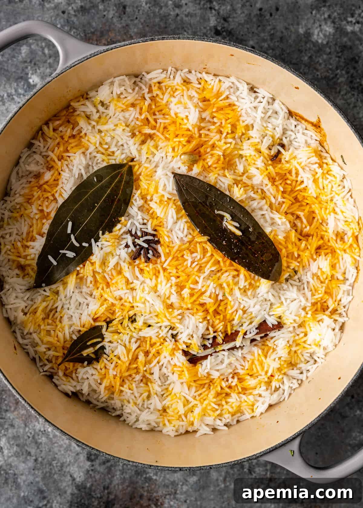 overhead process shot: rice and leaves drizzled with saffron and ghee