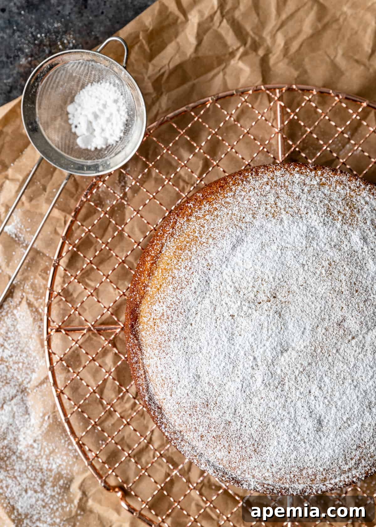 Process shot: the cooled olive oil cake beautifully dusted with powdered sugar as a simple and elegant topping.