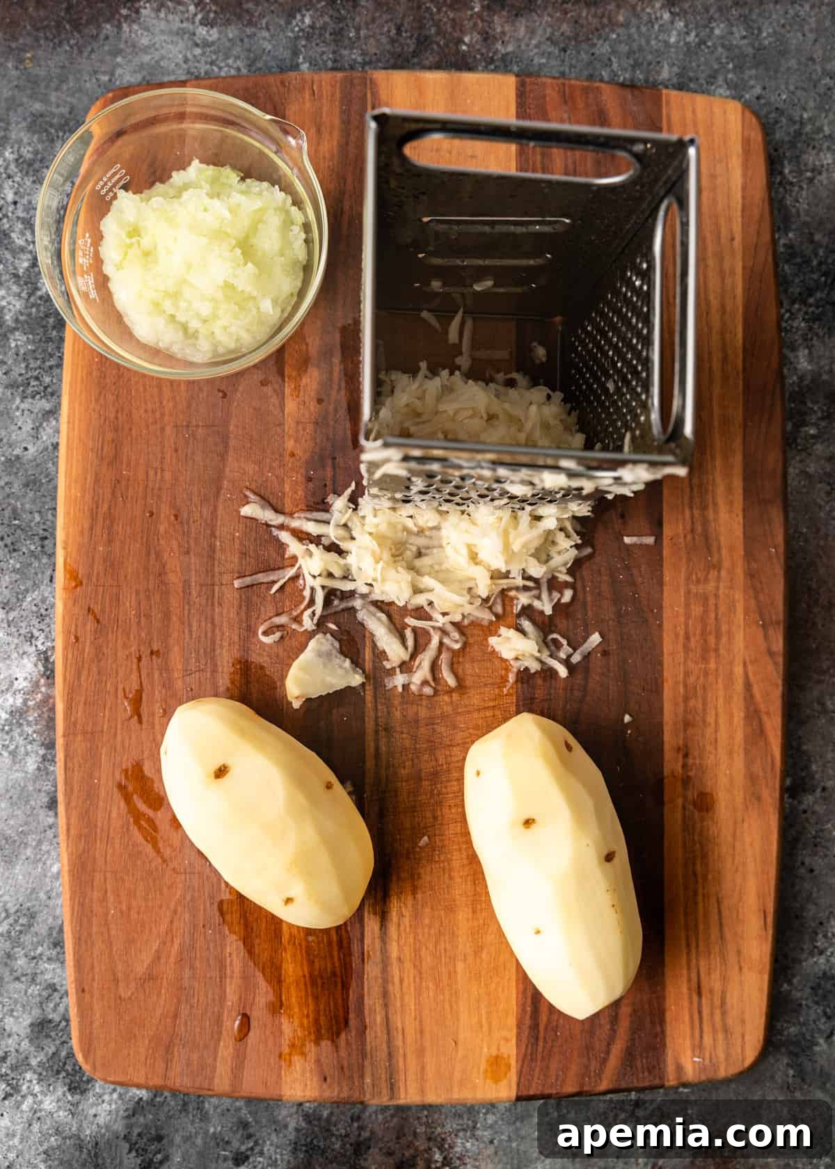 Overhead process shot detailing the shredding of onion and potatoes, the foundational ingredients for crispy latkes.