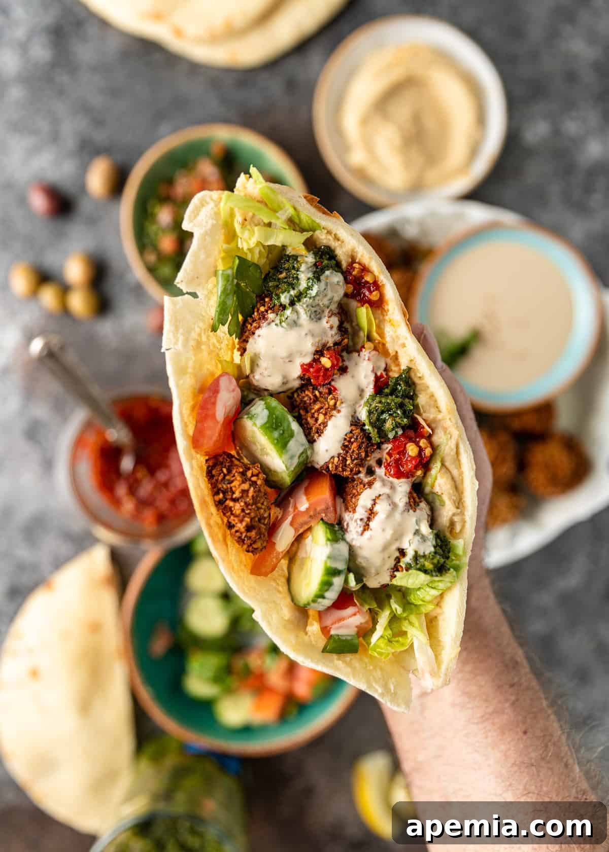 A perfectly prepared pita bread generously filled with crispy falafel, an assortment of fresh vegetables, and drizzled with a creamy tahini sauce, presented as a delicious and satisfying wrap.