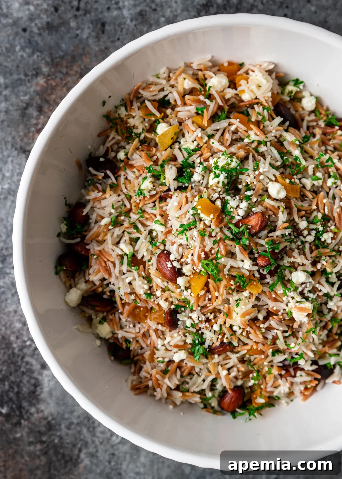 Sun-Drenched Mediterranean Rice Pilaf 3 Overhead view of a bowl filled with fluffy Mediterranean rice pilaf, showcasing its colorful toppings and inviting texture.