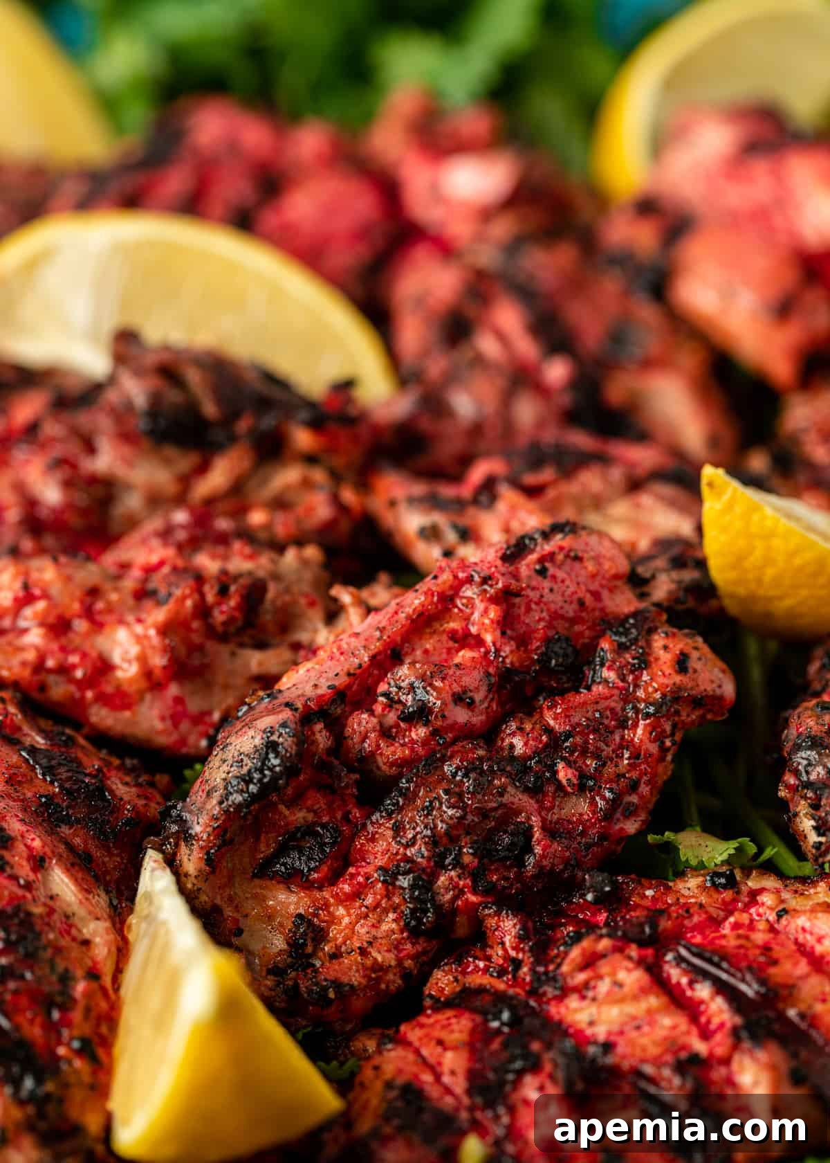 Close-up shot of cooked Tandoori Chicken, showing its charred exterior and juicy texture