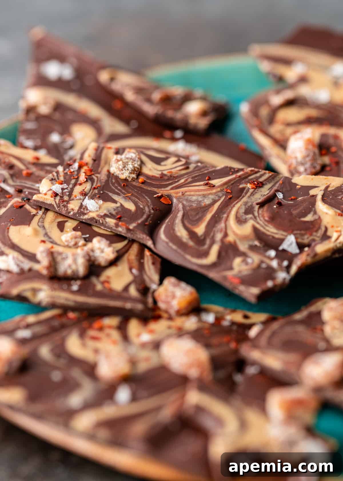 Closeup side view of a blue platter filled with freshly made Tahini Chocolate Bark, ready to be served.