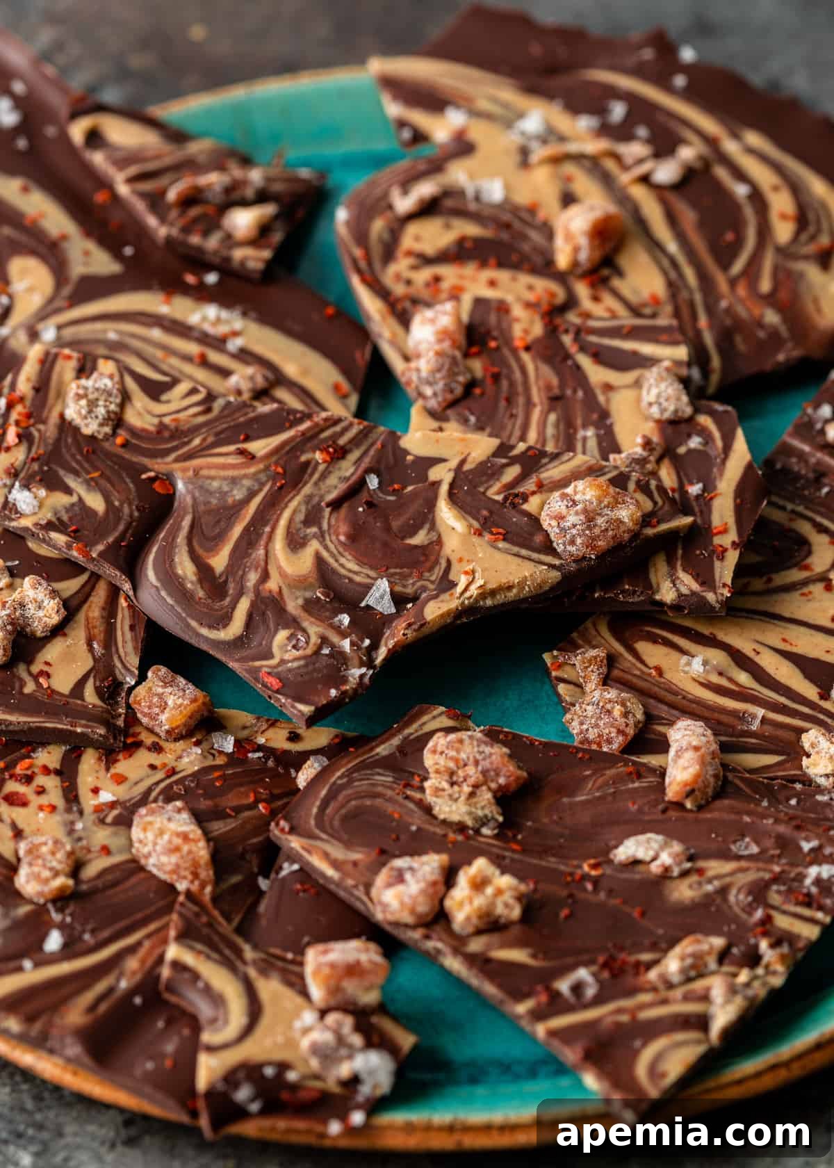 Closeup side view of a blue platter with ready-to-eat Tahini Chocolate Bark, highlighting its layers and toppings.