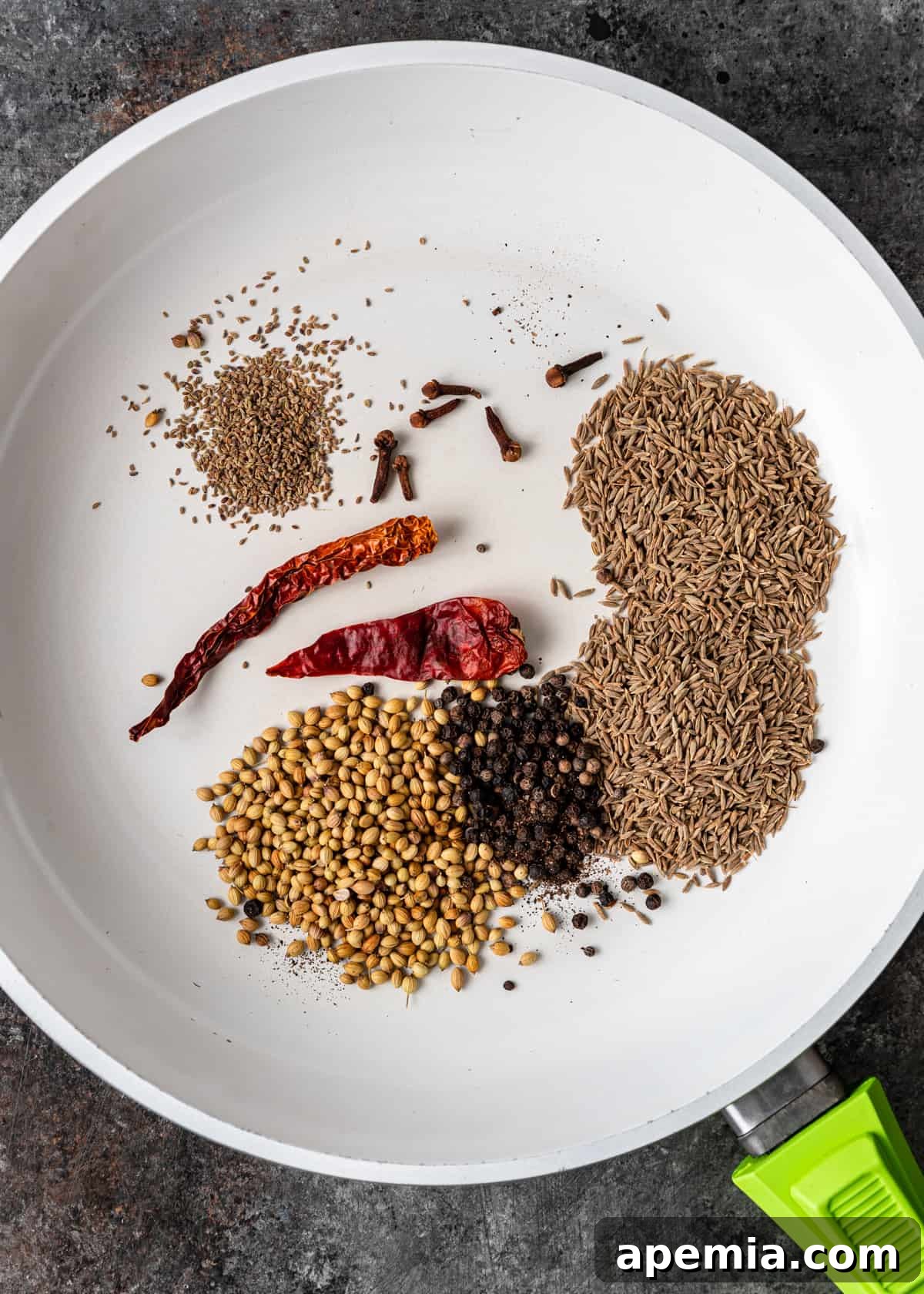 Overhead shot showcasing a variety of whole spices and powdered ingredients, neatly arranged for making homemade chaat masala from scratch.