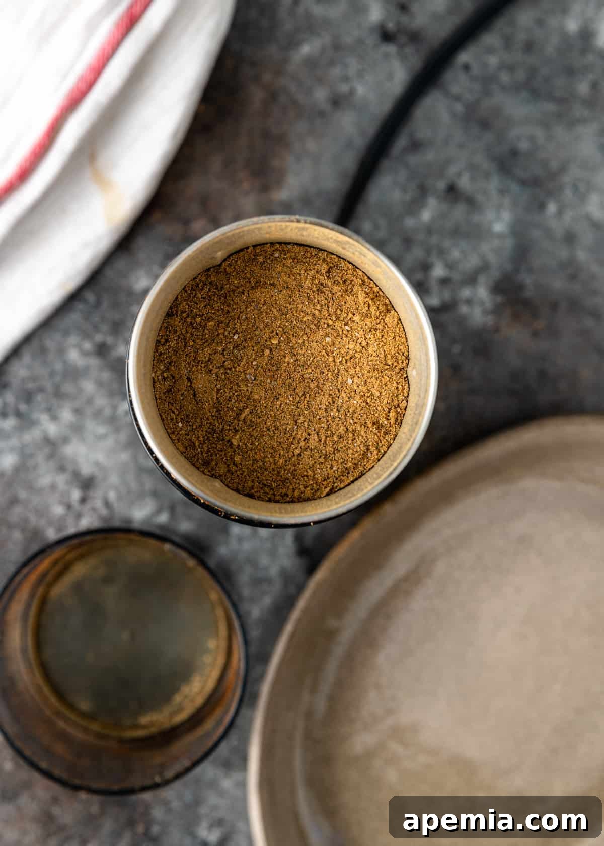 Overhead view of homemade chaat masala powder perfectly contained in a clear glass jar, labeled and ready for storage and use in the kitchen.