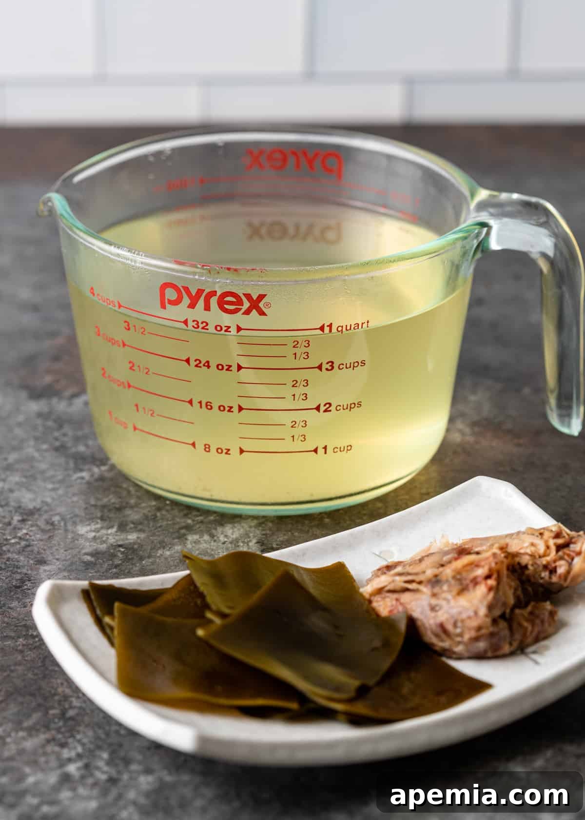 A glass measuring cup filled with freshly made Japanese soup stock (dashi).